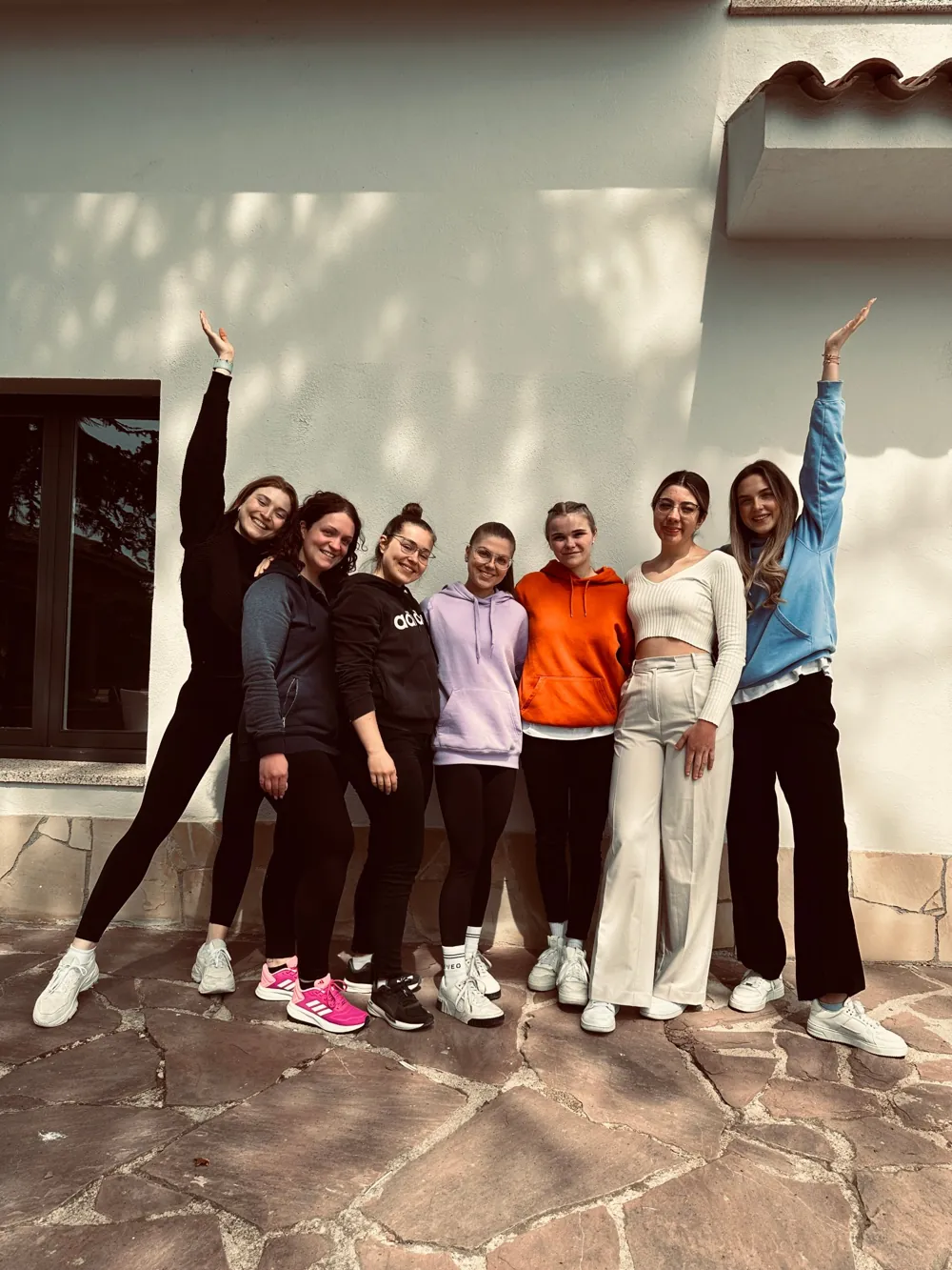 Lena mit Teilnehmerinnen eines Retreats vor einer weißen Hauswand